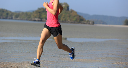 young healthy lifestyle asian woman running on beachの写真素材