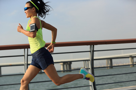 young fitness woman runner running at seasideの写真素材