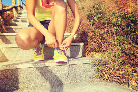 young fitness woman trail runner running up on mountain stairsの写真素材