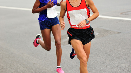 Marathon runners running on city roadの写真素材