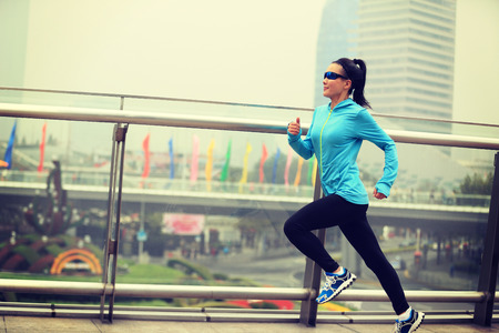 young fitness woman runner running at shanghai cityの写真素材