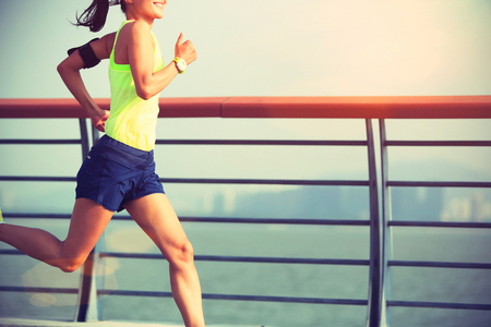 young fitness woman runner running at seasideの写真素材