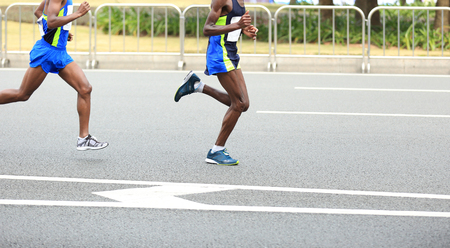 Marathon runner running on city roadの写真素材