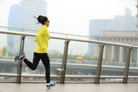 young fitness woman runner running at shanghai cityの写真素材