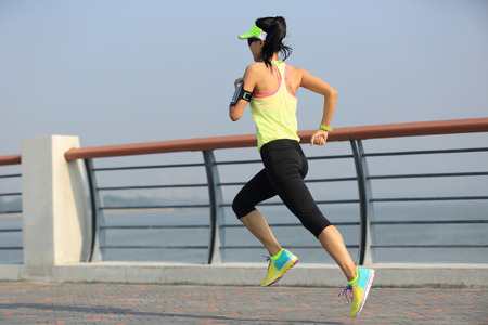 young fitness woman runner running at seasideの写真素材