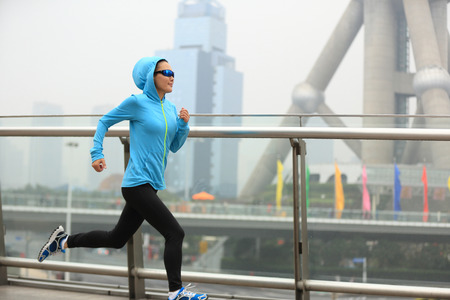 young fitness woman runner running at shanghai cityの写真素材