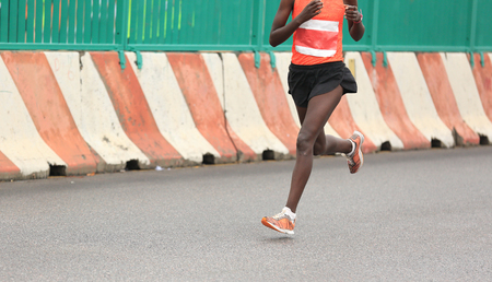 Marathon running race, people feet on city roadの写真素材