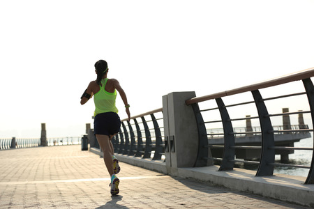 young fitness woman runner running at seasideの写真素材