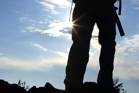 hiker legs on sunset mountain peak enjoy the viewの写真素材