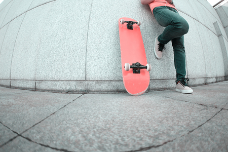 young skateboard use cellphone rest leaning on wallの写真素材