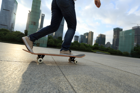 woman skateboarder riding on skateboard at cityの写真素材