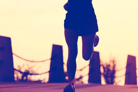 young fitness woman running on sunrise seaside trail