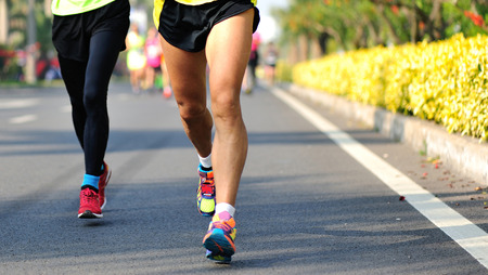 Marathon running race, people feet on city roadの写真素材