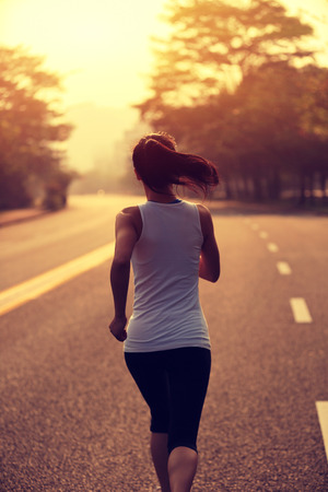 Runner athlete running at road. woman fitness jogging workout wellness concept.の写真素材