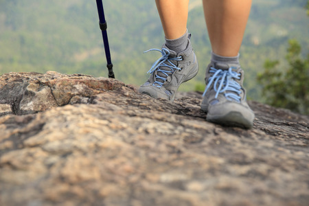woman hiker legs climbing rock at mountain peakの写真素材