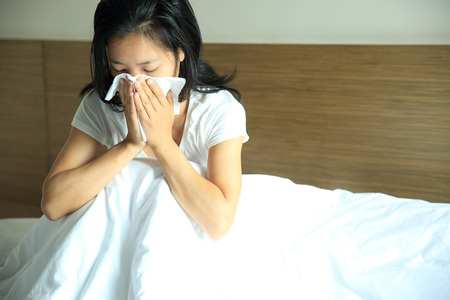 cough woman sneeze nose on bedの写真素材