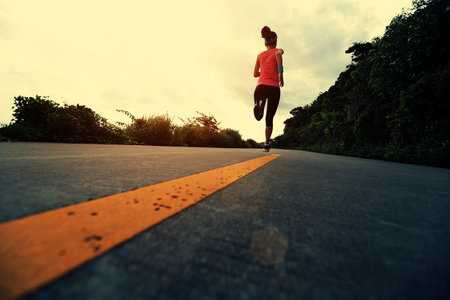 Runner athlete running at seaside road. woman fitness jogging workout wellness concept.の写真素材