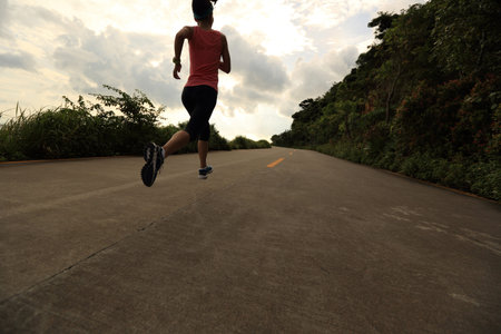 Runner athlete running at seaside road. woman fitness silhouette sunrise jogging workout wellness...