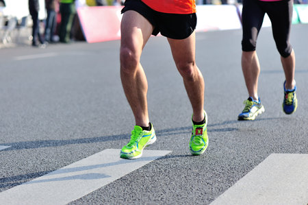 Marathon running race, people feet on city road