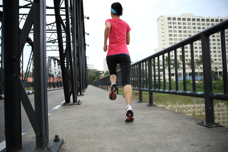 Runner athlete running on iron bridge. woman fitness jogging workout wellness concept.の写真素材