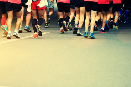 Unidentified marathon athletes legs running on city roadの写真素材