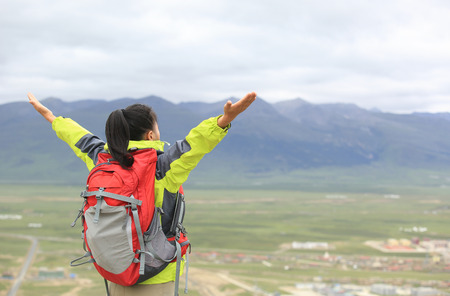 strong confident hiking woman enjoy the beautiful view at mountain peak in tibet,chinaの写真素材