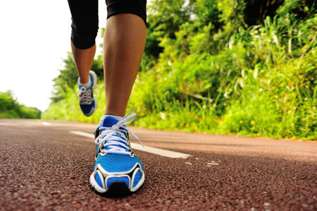 young fitness woman runner legs running at forest trail