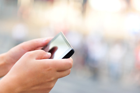 woman hands use cellphone in cityの写真素材