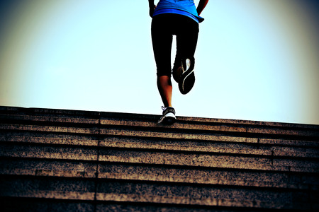 Runner athlete running on city stairs. woman fitness jogging workout wellness concept.の写真素材