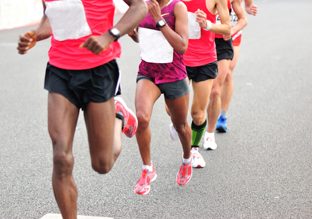 Marathon runners running on city roadの写真素材