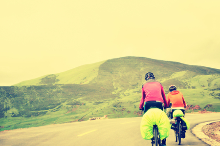 people cycling mountain bike climbing the mountain road in tibet, chinaの写真素材