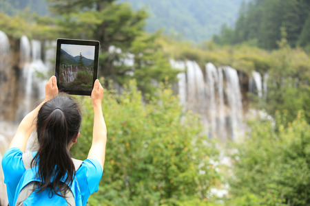 woman tourist taking photo with smart phoneの写真素材