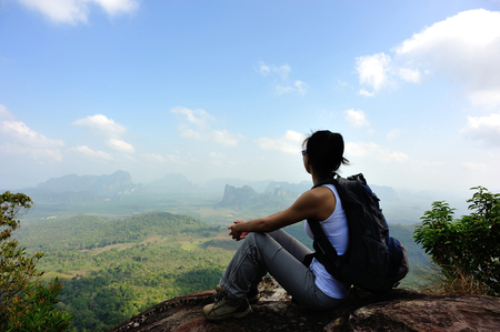 woman hiker enjoy the view at sunset mountain peak cliffの写真素材
