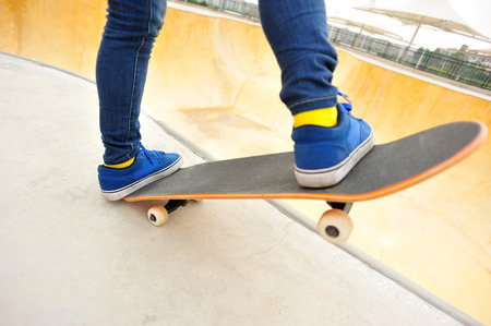 Feet in blue shoes skateboarding at skateparkの写真素材