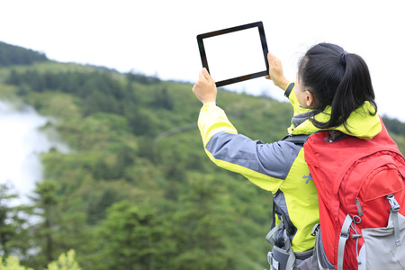 woman hiker in emei mountain taking photo with digital tabletの写真素材