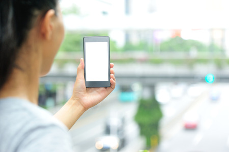 woman hands hold smart phone in modern cityの写真素材