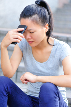woman with cellphone sit on cityの写真素材