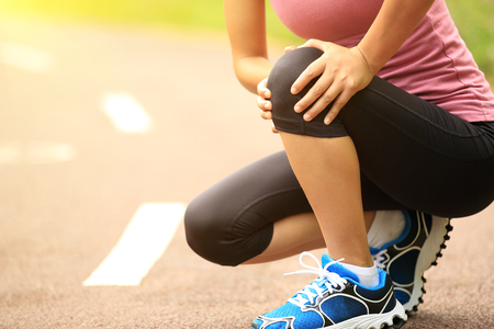 woman runner hold her injured kneeの写真素材