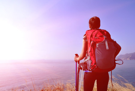 hiking woman stand under blue sky looking at the view