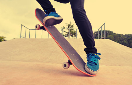young skateboarder legs skateboarding at skatepark