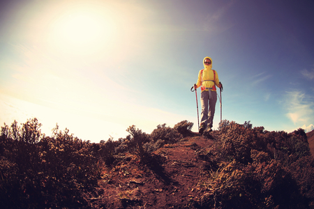 young woman backpacker climbing to mountain peakの写真素材