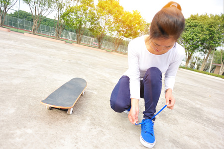 young woman  trying new shoes beside skateboardの写真素材