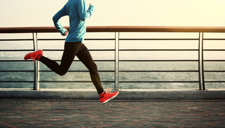 young fitness woman jogging at seasideの写真素材