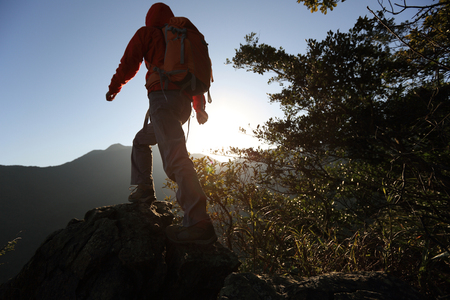 young woman hiker hiking on sunrise mountain peakの写真素材
