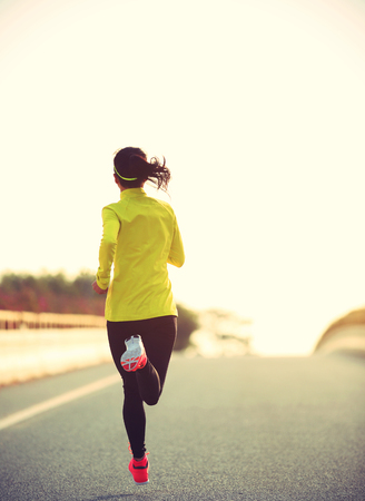 young fitness woman runner running on roadの写真素材