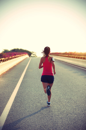 young fitness woman runner running on roadの写真素材