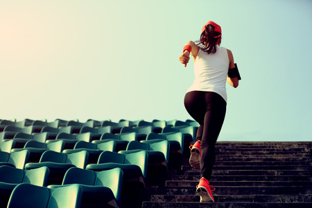 Runner athlete running on stairs. woman fitness jogging workout wellness concept.の写真素材