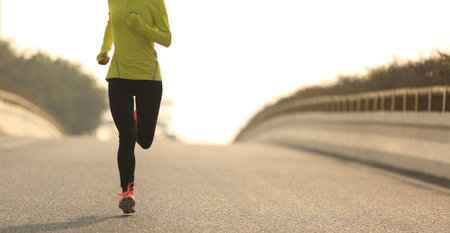 young fitness woman trail runner running  on city road