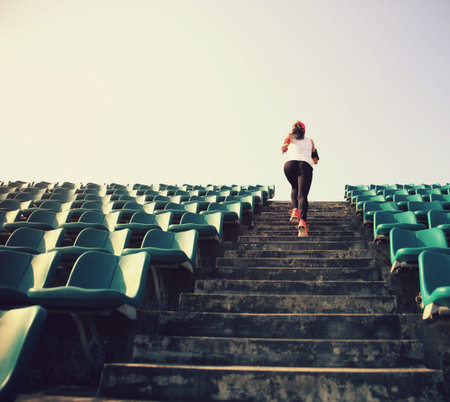 Runner athlete running on stairs. woman fitness jogging workout wellness concept.