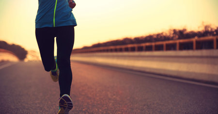 young fitness woman runner athlete running on sunrise roadの写真素材